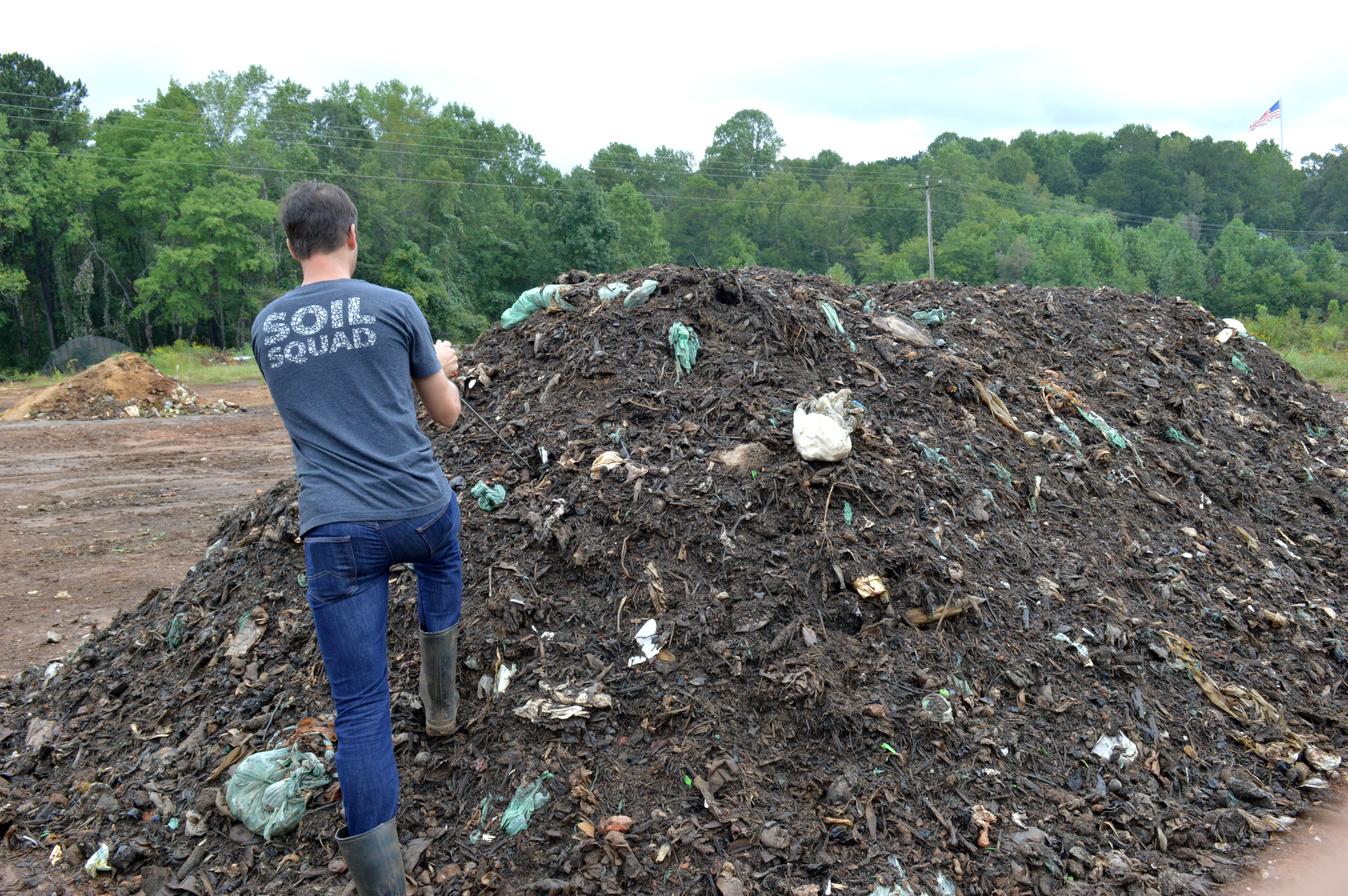 David Paull examining a compost pile
