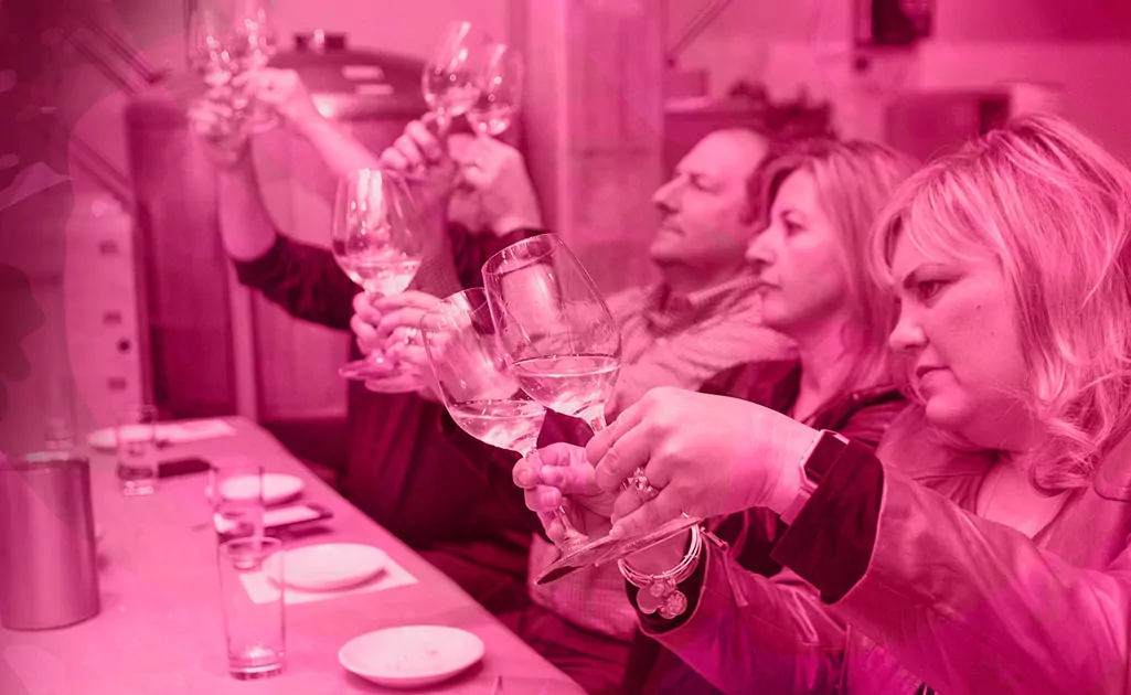 Group of people comparing 2 glasses of wine per person.