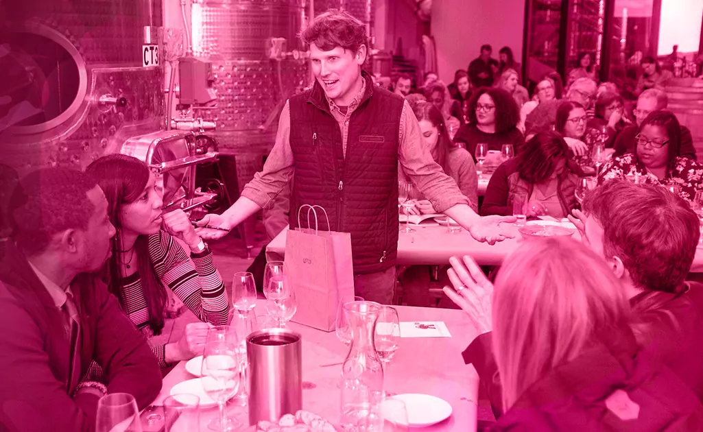 Man talking to group of diners with wine at a restaurant
