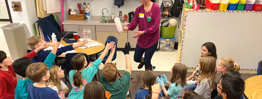 Paula Garcia Todd showing a cloud in a bottle to a group of students.