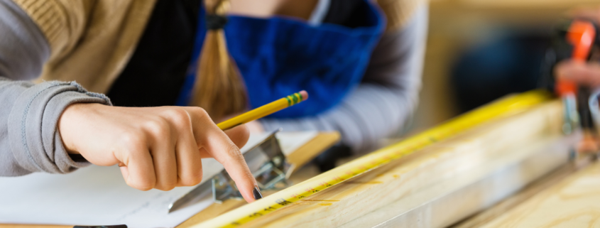 Close-up shot of a young woman in a makerspace working on a project.