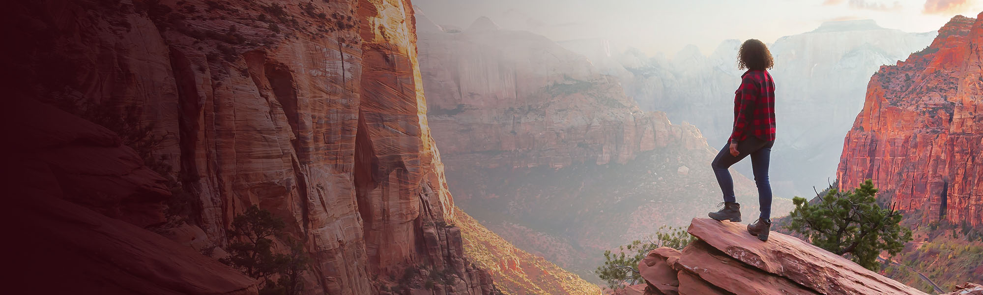 A person standing on a rock in the Grand Canyon, looking out at the beautiful view.