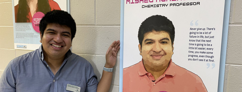 Misael Romero-Reyes standing in front of a poster about himself as a scientist.