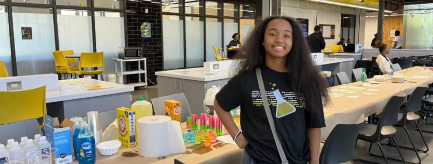 Person smiling in front of science academy set up