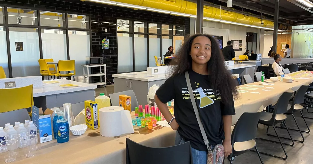 Person smiling in front of science academy set up