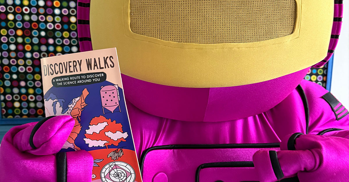 ALEX holding a Discovery Walks brochure.