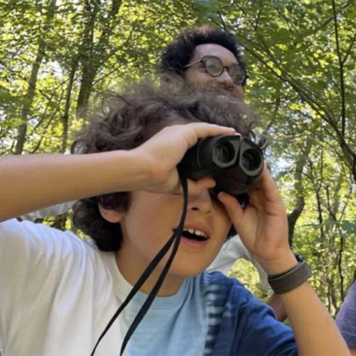 A child looking through binoculars